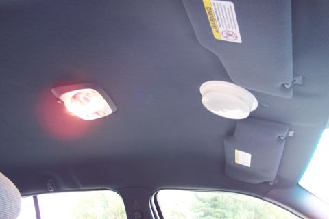2001 Ford Crown Victoria - The interior ceiling of a vehicle, two dome lights and a sun visor with a warning label.