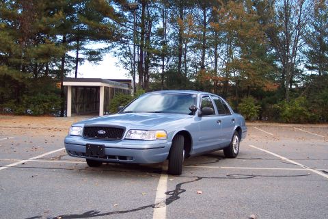 2001 Ford Crown Victoria - Blue 2001 Ford Crown Victoria parked in an outdoor lot during the day.