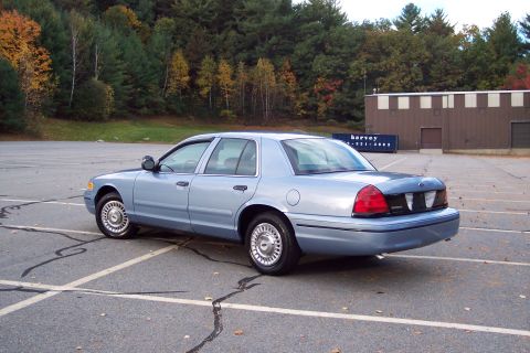 2001 Ford Crown Victoria - Light blue 2001 Ford Crown Victoria parked in an empty lot during autumn.