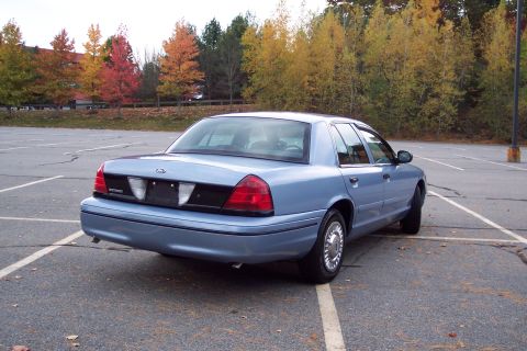 2001 Ford Crown Victoria - Rear view of a blue 2001 Ford Crown Victoria sedan parked in a lot during autumn.