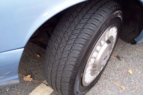 2001 Ford Crown Victoria - Goodyear tire on a light blue car's wheel.