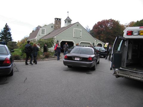 2001 Ford Crown Victoria - Several vehicles, including a police car and an ambulance, are parked in front of a house.