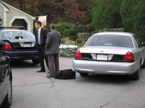 2001 Ford Crown Victoria - A silver 2001 Ford Crown Victoria is parked next to a police car, with two men standing nearby.