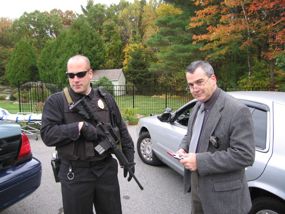 Silver 2001 Ford Crown Victoria police car, side view, with two men standing nearby