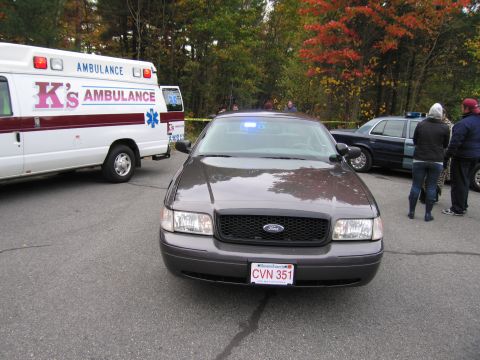 2001 Ford Crown Victoria - Police car and ambulance at scene, with autumn trees in background.