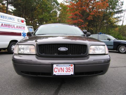 2001 Ford Crown Victoria - 2001 Ford Crown Victoria police car parked next to an ambulance and another police vehicle.