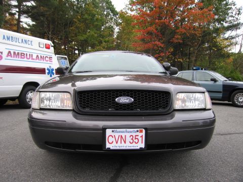 2001 Ford Crown Victoria - A 2001 Ford Crown Victoria Police Interceptor is parked next to an ambulance and a police car.