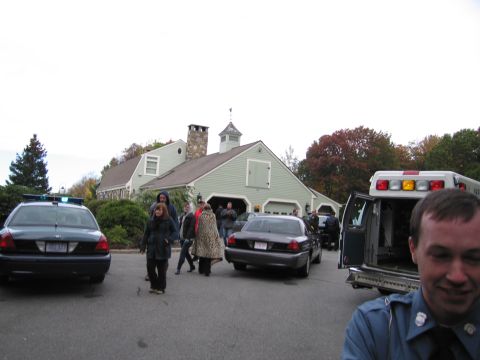 2001 Ford Crown Victoria - Emergency vehicles and personnel are gathered at a residence on an overcast day.