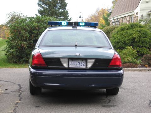 2001 Ford Crown Victoria - Rear view of a 2001 Ford Crown Victoria police car, equipped with a light bar and Massachusetts plates.
