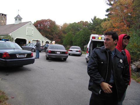 2001 Ford Crown Victoria - Several vehicles, including police cars and an ambulance, are parked outside a building.