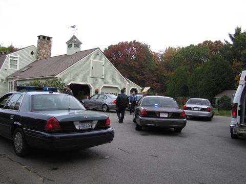 2001 Ford Crown Victoria - Several police vehicles and a sedan are parked in front of a house with a cupola.