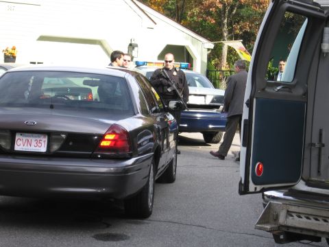 2001 Ford Crown Victoria - Police officers stand near a Ford Crown Victoria and another police vehicle at a scene.