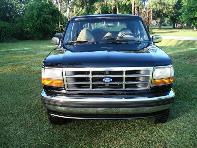 Black Ford Bronco front view, chrome grille, amber turn signals, parked on grass