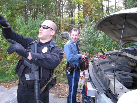 2001 Ford Crown Victoria - Police officers are seen attempting to jump-start a vehicle in a wooded area.