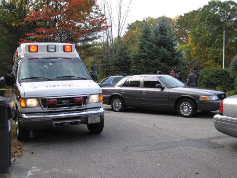 2001 Ford Crown Victoria - A 2001 Ford Crown Victoria is parked next to an ambulance, with several people standing nearby.