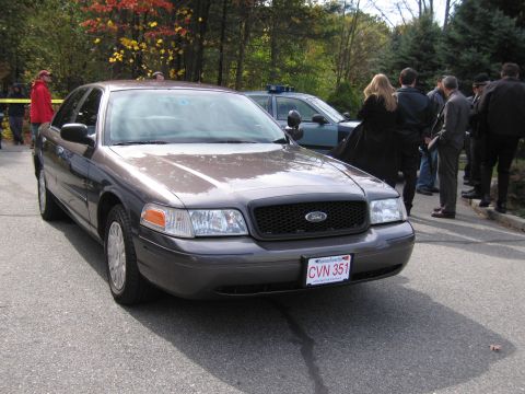 2001 Ford Crown Victoria - Front view of a 2001 Ford Crown Victoria, with a police car visible behind it.