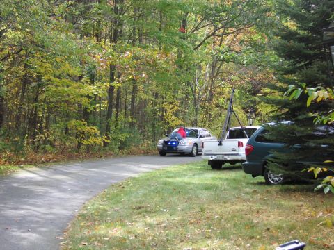 2001 Ford Crown Victoria - A police car and a pickup truck are parked on a driveway surrounded by trees with autumn foliage.
