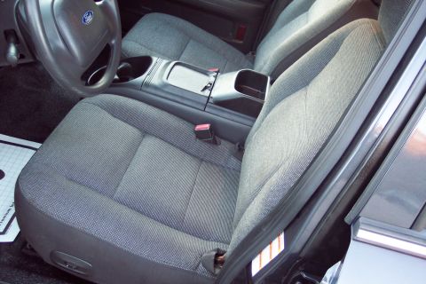 2001 Ford Crown Victoria - The interior of a 2001 Ford Crown Victoria shows grey fabric seats and a black steering wheel.