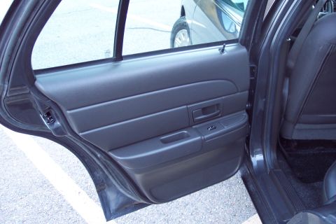 2001 Ford Crown Victoria - The interior door panel and rear seat of a 2001 Ford Crown Victoria are visible in this photograph.