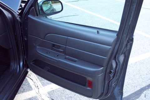 2001 Ford Crown Victoria - Interior view of a dark gray door panel horizontal ridges and power window controls.