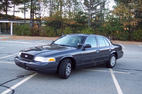 2001 Ford Crown Victoria - This dark gray 2001 Ford Crown Victoria sedan is shown from a three-quarter front view in a parking lot.