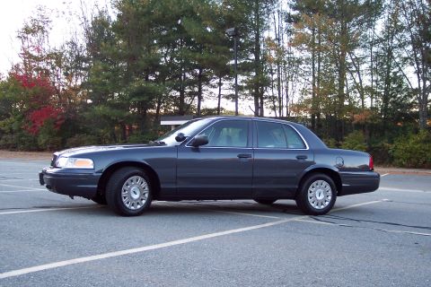 2001 Ford Crown Victoria - Side view of a dark gray 2001 Ford Crown Victoria sedan in a parking lot.