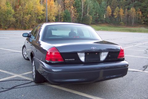 2001 Ford Crown Victoria - This Ford Crown Victoria is parked in an empty lot with trees in the background showing autumn foliage.