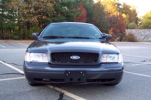 2001 Ford Crown Victoria - Front view of a dark blue 2001 Ford Crown Victoria parked in a lot with autumn trees in the background.