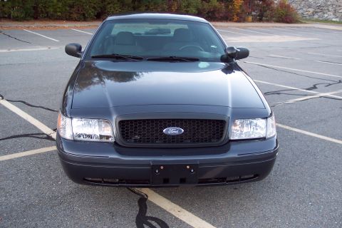 2001 Ford Crown Victoria - Front view of a dark colored 2001 Ford Crown Victoria parked in a lot.