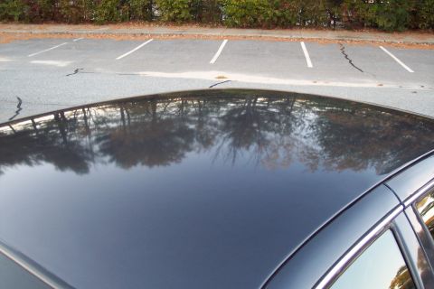 2001 Ford Crown Victoria - The reflection on the car's roof shows trees and a parking lot.