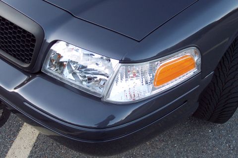 2001 Ford Crown Victoria - Front corner view of a dark gray 2001 Ford Crown Victoria, its black grille and amber turn signal.