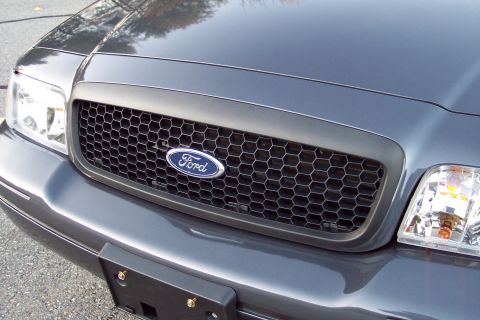 2001 Ford Crown Victoria - Close-up of the front grille and headlights of a Ford Crown Victoria, showing the Ford emblem.