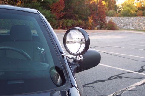 2001 Ford Crown Victoria - A 2001 Ford Crown Victoria police car is viewed from the side, showing its spotlight mounted on the A-pillar.