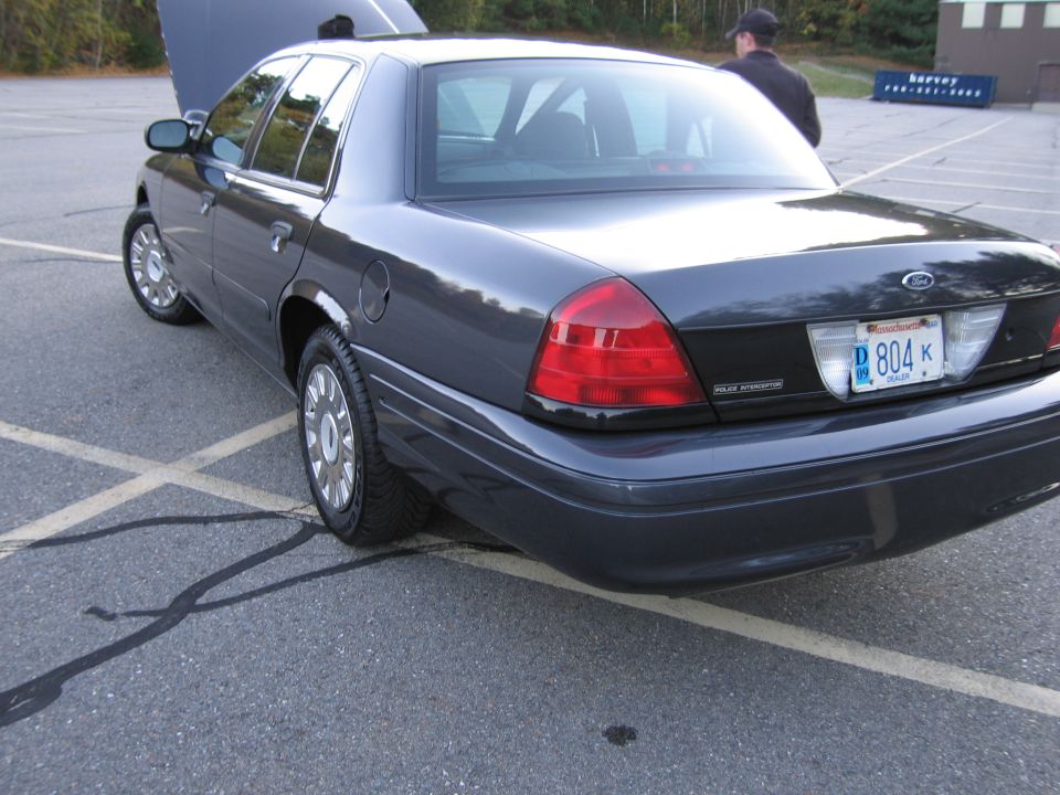 Photo of a dark Ford Crown Victoria rear three-quarter view in a lot