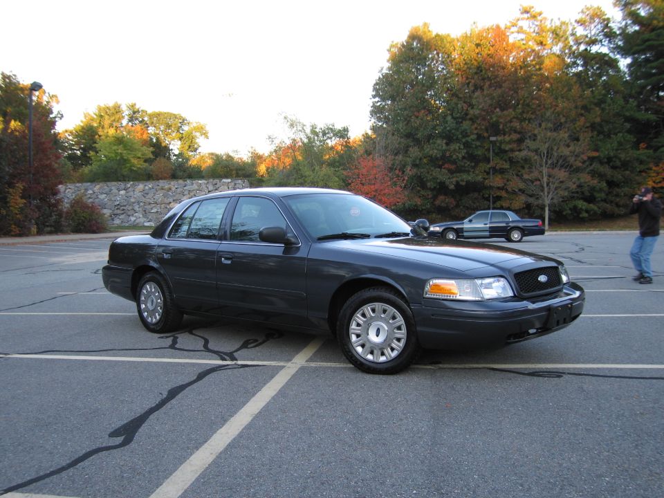 Photo of a dark Ford Crown Victoria parked at an angle in a lot
