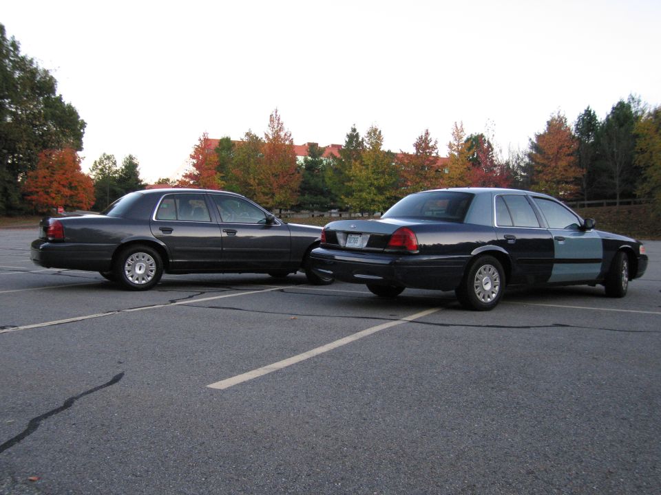 Two Ford Crown Victoria sedans parked rear views