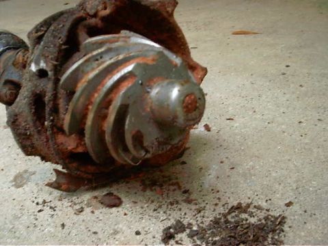 1985 Ford Bronco - A heavily corroded differential gear assembly rests on a concrete floor, showing signs of significant wear and tear.