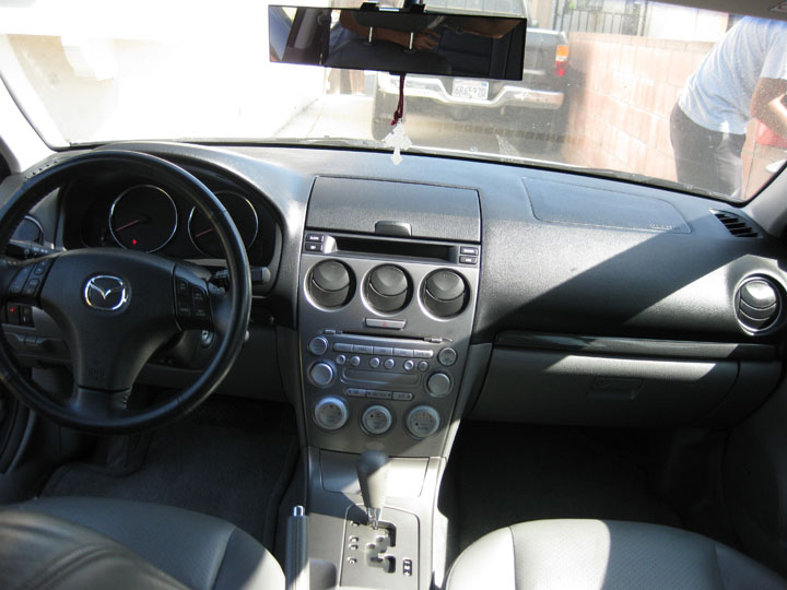 Interior view of a Mazda car dashboard, steering wheel, and center console.