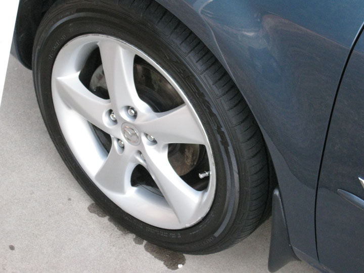 Dark blue Mazda passenger car front wheel and fender