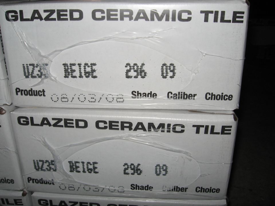 Two stacked boxes of beige ceramic tile with product information.