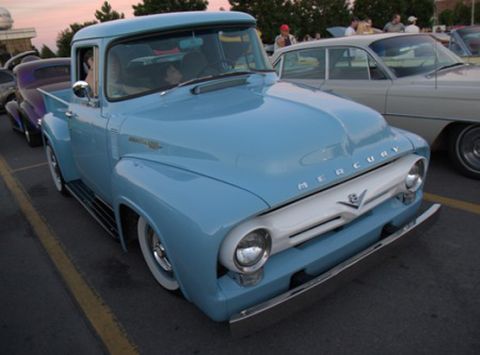 1991 Ford Bronco - A light blue 1950s Mercury pickup truck is parked at an outdoor event, possibly a car show. The truck features a white grille with the Merc…