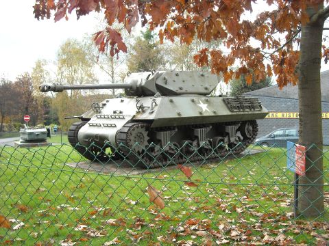 1979 Ford F-150 - A Sherman tank is displayed outdoors, with autumn leaves on the trees and ground.