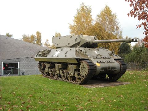 1979 Ford F-150 - A military tank with tracks and a large cannon is displayed outdoors on a grassy area.