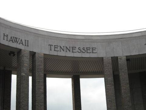 1979 Ford F-150 - A monument features carved names of states, including Hawaii and Tennessee, under a cloudy sky.