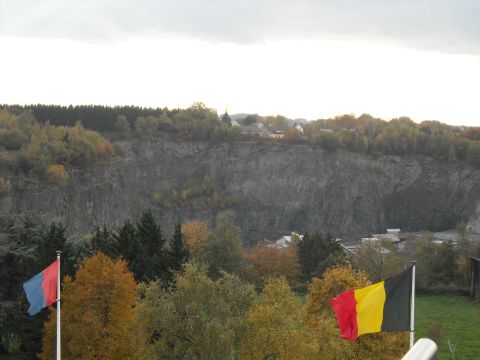 1979 Ford F-150 - A quarry landscape under a cloudy sky, with two flags in the foreground and autumn foliage.