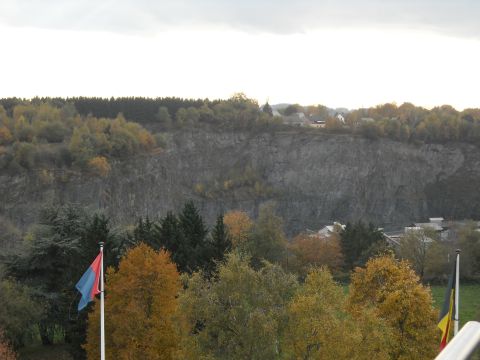 1979 Ford F-150 - A wide view of a quarry with trees in autumn colors and a cloudy sky overhead.
