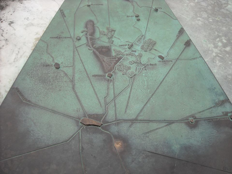 Photo of a green patinated bronze relief battle map of the Bastogne region