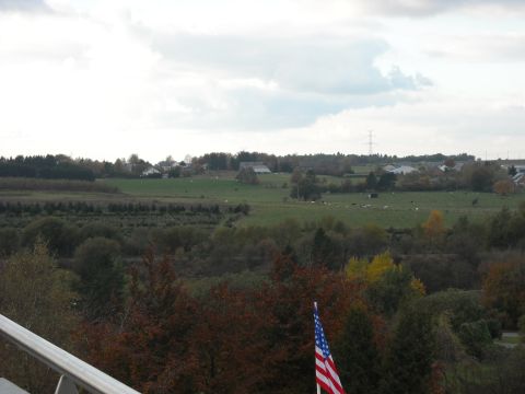 1979 Ford F-150 - American flag flies over a rural landscape with fields and scattered buildings.