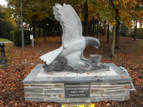 1979 Ford F-150 - Memorial statue of an eagle holding a bucket, located outdoors with fallen leaves and trees in the background.