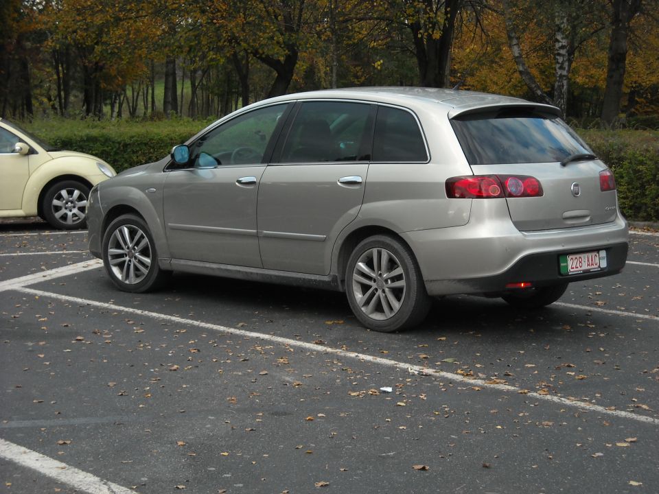 Silver station wagon parked in a lot, rear view. License plate reads 228 AAC